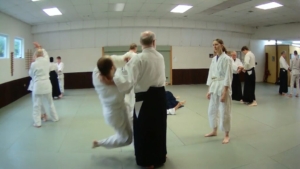 Instructor coaches two students at aikido practice