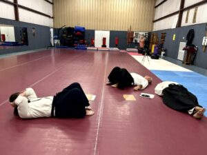 Three Aikidoka relaxing on the mats