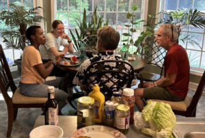 people gathered at a table with food and conversation